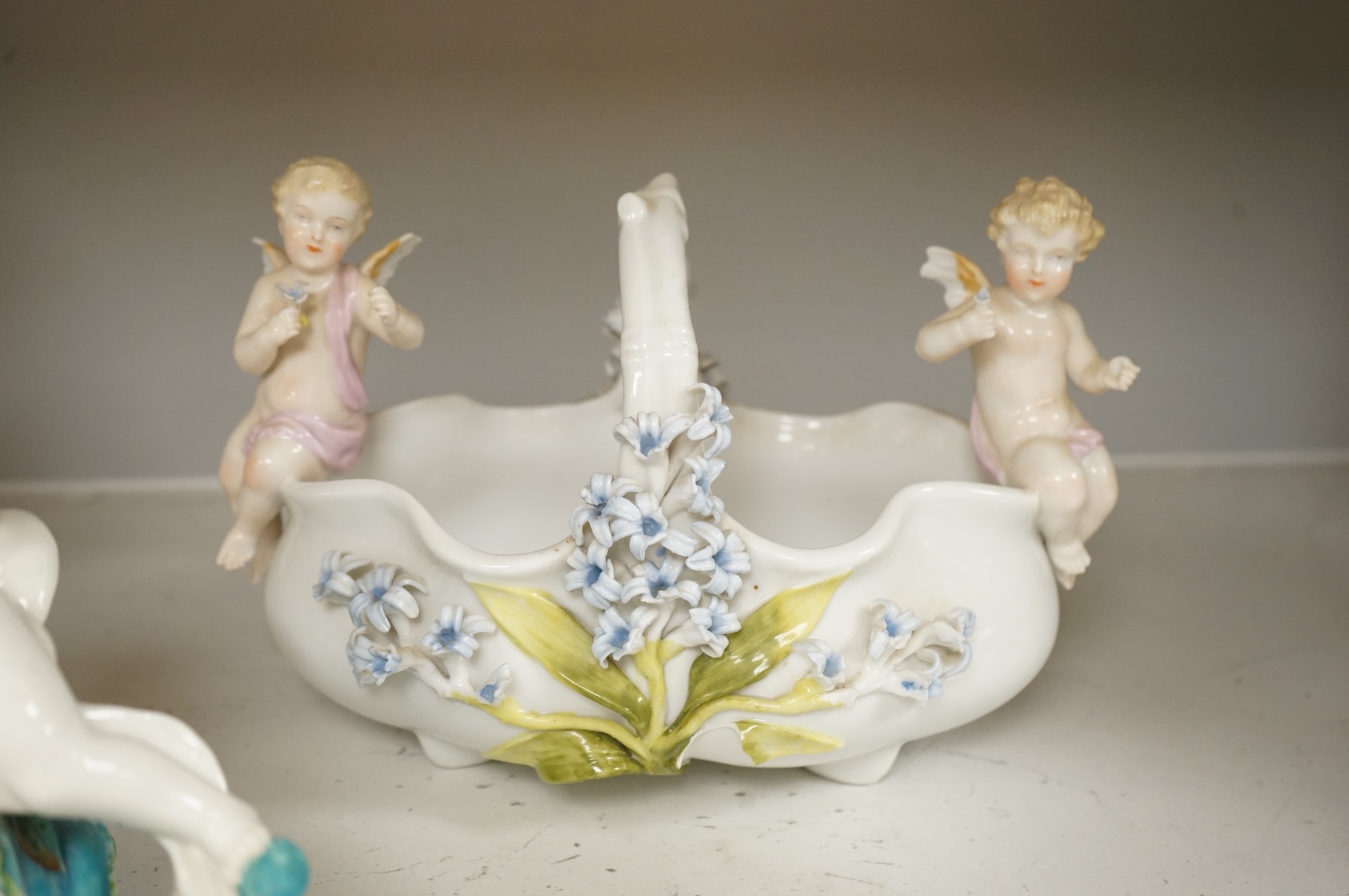 A pair of Sitzendorf figurines, damage to one, a pair of candlesticks, a Rye pottery dish, a Moore Bros. wall pocket, a doll and a basket, tallest 22.5cm